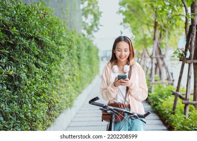 Happy Asian young woman walking with bicycle using mobile phone in park, street city her smiling using bike of transportation, ECO friendly, People lifestyle concept.
 - Powered by Shutterstock