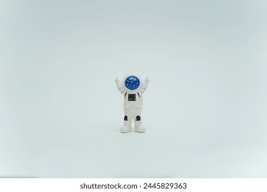 Happy astronaut standing with raised hands. Plastic toy figure astronaut on a white background. Copy space. Close-up. The concept of space and space man.  - Powered by Shutterstock