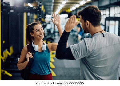 Happy athlete and her fitness instructor giving high five after finished sports training in a gym. - Powered by Shutterstock