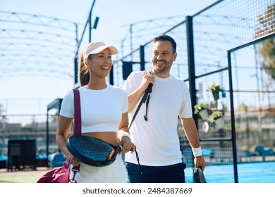 Happy athlete and his female friends playing paddle tennis on outdoor court. Copy space. - Powered by Shutterstock