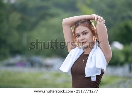 Happy athletic beautiful healthy lifestyle sport motivated female woman taking rest brake while jogging in the park, Young woman smiling use sweat towel and warm down relaxing exercise cooldown park