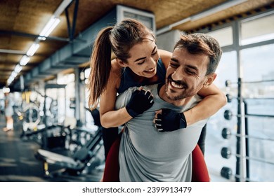 Happy athletic couple having fun while piggybacking in health club. - Powered by Shutterstock