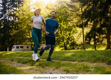 Happy athletic couple jogging together through the park. Copy space. - Powered by Shutterstock