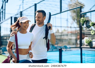 Happy athletic couple leaving the court after playing paddle tennis. - Powered by Shutterstock