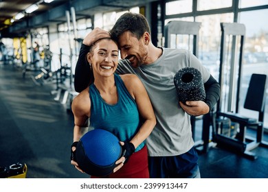 Happy athletic couple working out together in a gym. The woman is looking at camera.  - Powered by Shutterstock