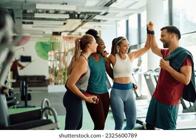 Happy athletic friends congratulating each other on successful sports training in a gym.  - Powered by Shutterstock