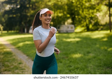 Happy athletic woman running while exercising in nature. Copy space. - Powered by Shutterstock