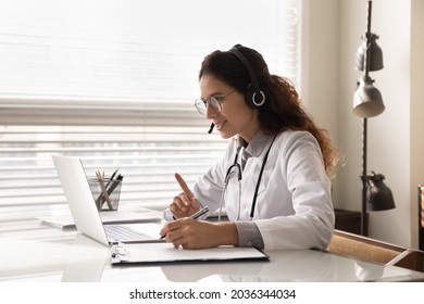 Happy Attentive General Practitioner In Headset Using Laptop, Giving Online Help, Medical Support, Advice, Consultation, Talking To Patients, Making Video Conference Call. Telehealth Concept