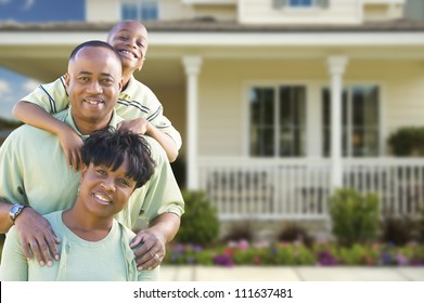 Happy Attractive African American Family in Front of Beautiful House.