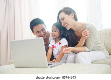 Happy Attractive Asian Family Using Laptop With Daugther