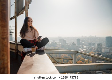 Happy attractive Asian female listening to music outdoors stock photo