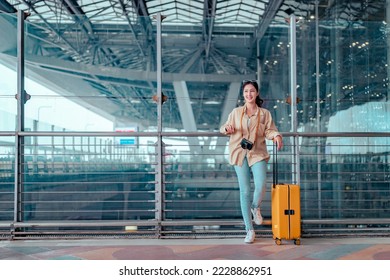 Happy attractive asian woman passenger traveler with a yellow suitcase at the modern airport terminal, copy space, Tourist journey trip concept - Powered by Shutterstock