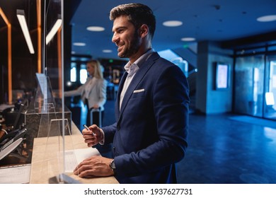 Happy Attractive Businessman Standing At A Reception In The Luxury Hotel And Checking In. Travel Destinations, Love My Job, Business Trip