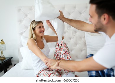 Happy Attractive Couple Play Fighting With Pillows