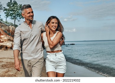 Happy attractive couple walking on beautiful sunny beach. Copy space - Powered by Shutterstock