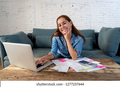 Happy Attractive Housewife Entrepreneur Woman Accounting Costs Charges Mortgage Taxes And Paying Bills With Laptop And Calculator Sitting On Sofa At Home In Banking And Success Finances Free Of Debt.