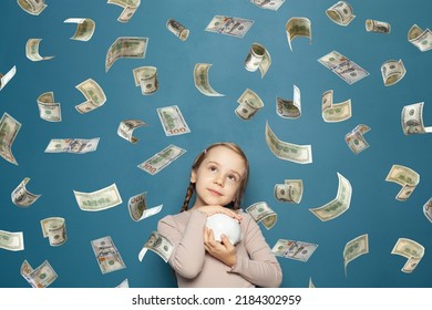 Happy Attractive Little Kid On Falling Money Rain On Blue Background