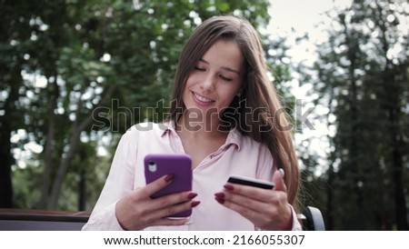 Happy attractive woman shopping online with credit card and smart phone.