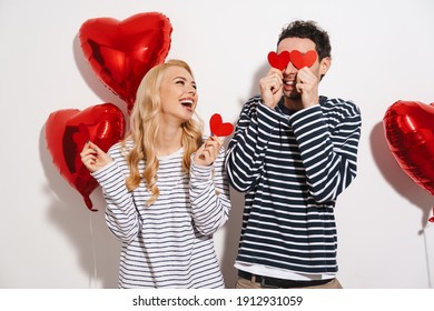 Happy Attractive Young Couple Celebrating Valentines Day With Red Heart Shaped Balloons Isolated Over White Background