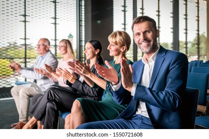 Happy Audience Applauding Speaker At Business Conference