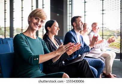 Happy Audience Applauding Speaker At Business Conference