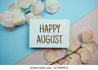 Happy August Text Message With Artificial Leave On Blue And Pink Background