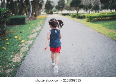 Happy Baby Asian Girl Smiling. Little Girl Running At Sunset Happy Baby Girl Smiling. Little Baby Running At Sunset. Cute Baby Running At Playground Garden.