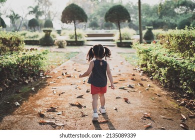 Happy Baby Asian Girl Smiling. Little Girl Running At Sunset Happy Baby Girl Smiling. Little Baby Running At Sunset. Cute Baby Running At Playground Garden.