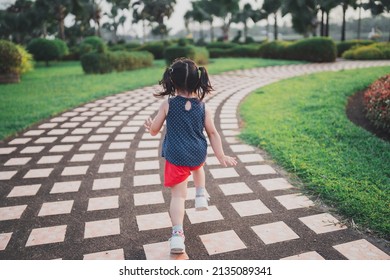 Happy Baby Asian Girl Smiling. Little Girl Running At Sunset Happy Baby Girl Smiling. Little Baby Running At Sunset. Cute Baby Running At Playground Garden.