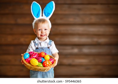 Happy Baby Boy In Easter Bunny Suit With A Basket Of Eggs
