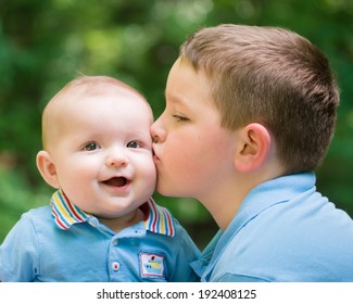 Happy Baby Boy Kissed By His Older Brother