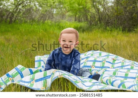 Similar – Image, Stock Photo Child laughing joyfully while making a snow angel, dressed in a vibrant winter coat and hat