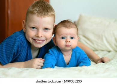 Happy Baby Boy Playing With Bigger Brother