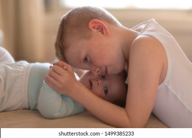 Happy Baby Boy Playing With Bigger Brother