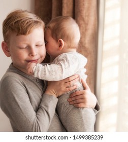 Happy Baby Boy Playing With Bigger Brother