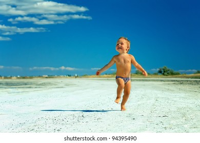 Happy Baby Boy Running The Road Near The Seaside