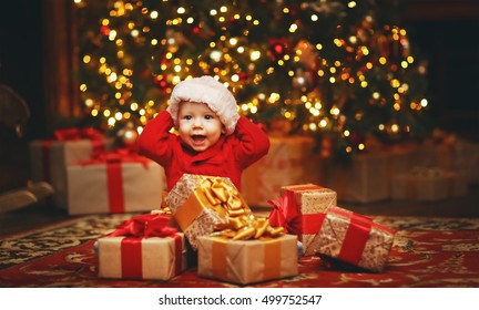 Happy Baby By A Christmas Tree With Gifts