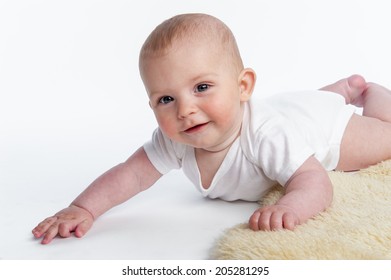 Happy baby crawling on sheepskin rug