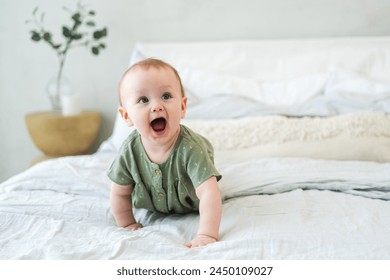 Happy baby. Cute little newborn girl with smiling face crawling on bed in bedroom. Infant baby resting playing lying down on blanket at home. Motherhood happy child childcare concept - Powered by Shutterstock