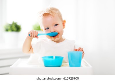 Happy Baby Eating Himself With A Spoon