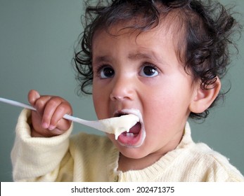 Happy Baby Eating Porridge With Spoon