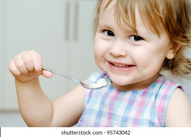 Happy baby eating porridge with spoon