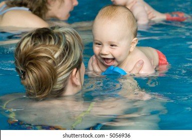 A Happy Baby Enjoying First Swim With Mother.
