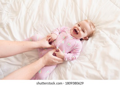 Happy baby girl in jammies being tickled