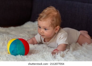 Happy Baby girl playing with toy ball.Toddler kid with balls for children.