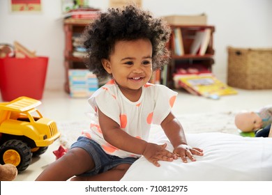 Happy Baby Girl Playing With Toys In Playroom