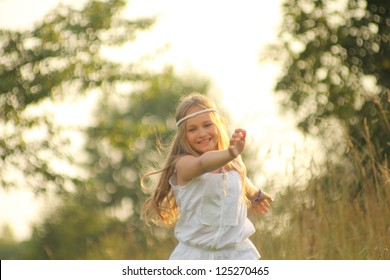 happy baby girl runs across the grass