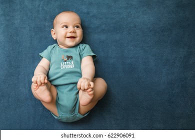 Happy baby holding feet in funny pose - Shutterstock ID 622906091