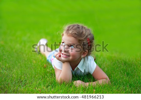 Similar – Littel girl sitting on grass looking curious