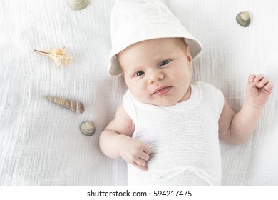 Happy Baby Playing Air Guitar On Blanket At Beach